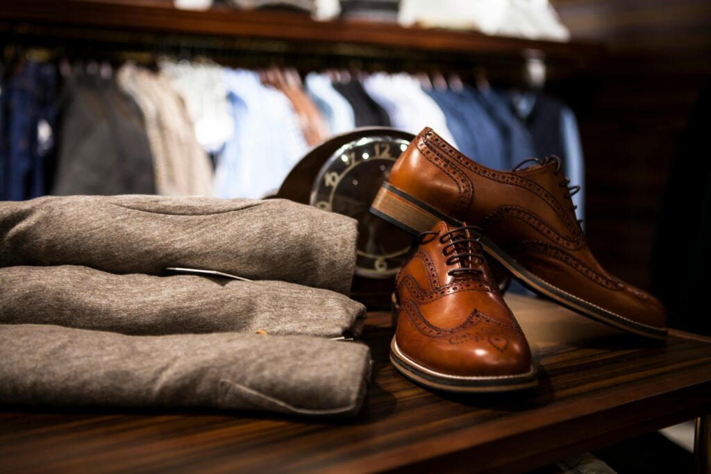 Stylish leather shoes displayed with gray clothing in a chic boutique setting.