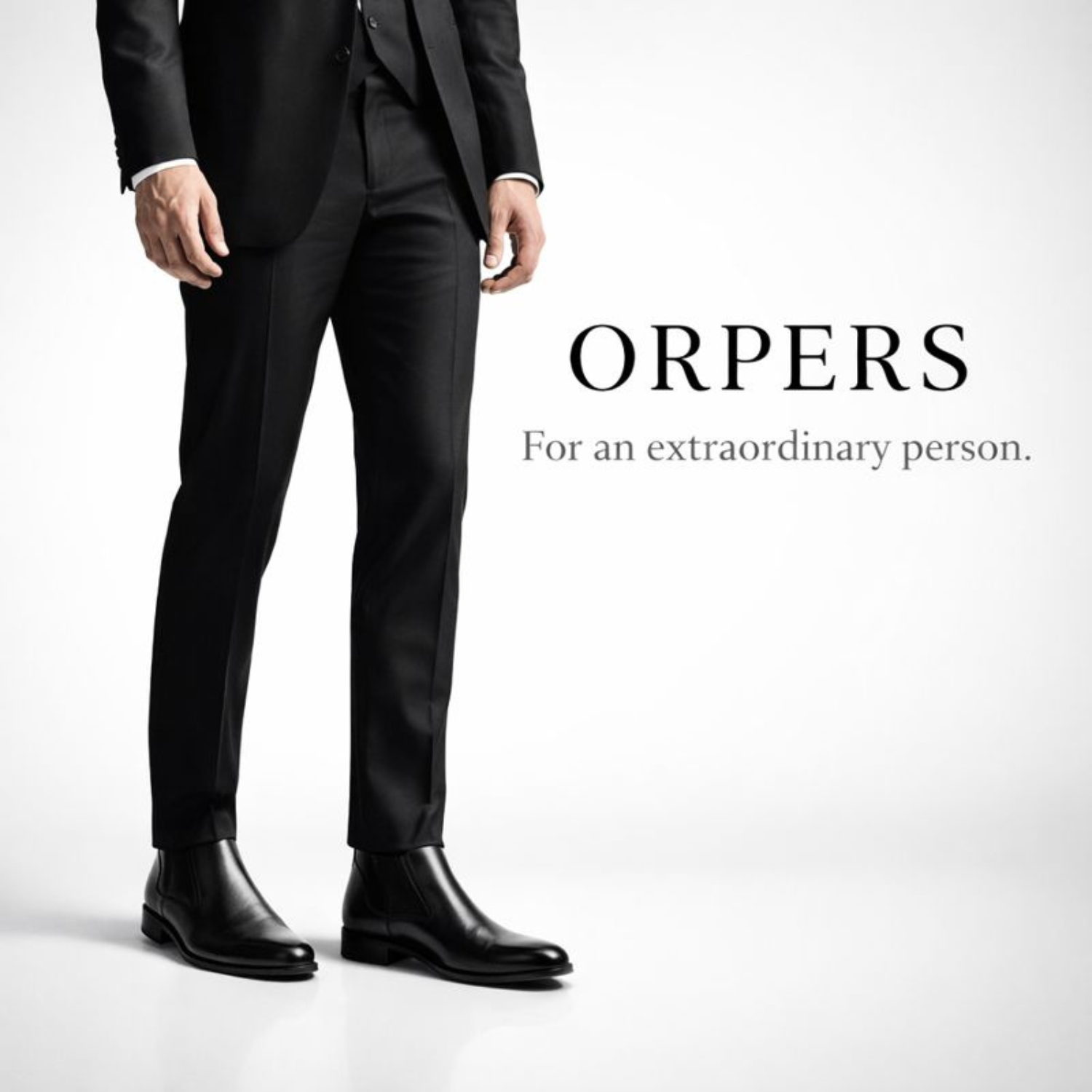 Man wearing black formal suit styled with black leather Chelsea boots beside ORPERS brand name and tagline “For an extraordinary person.”